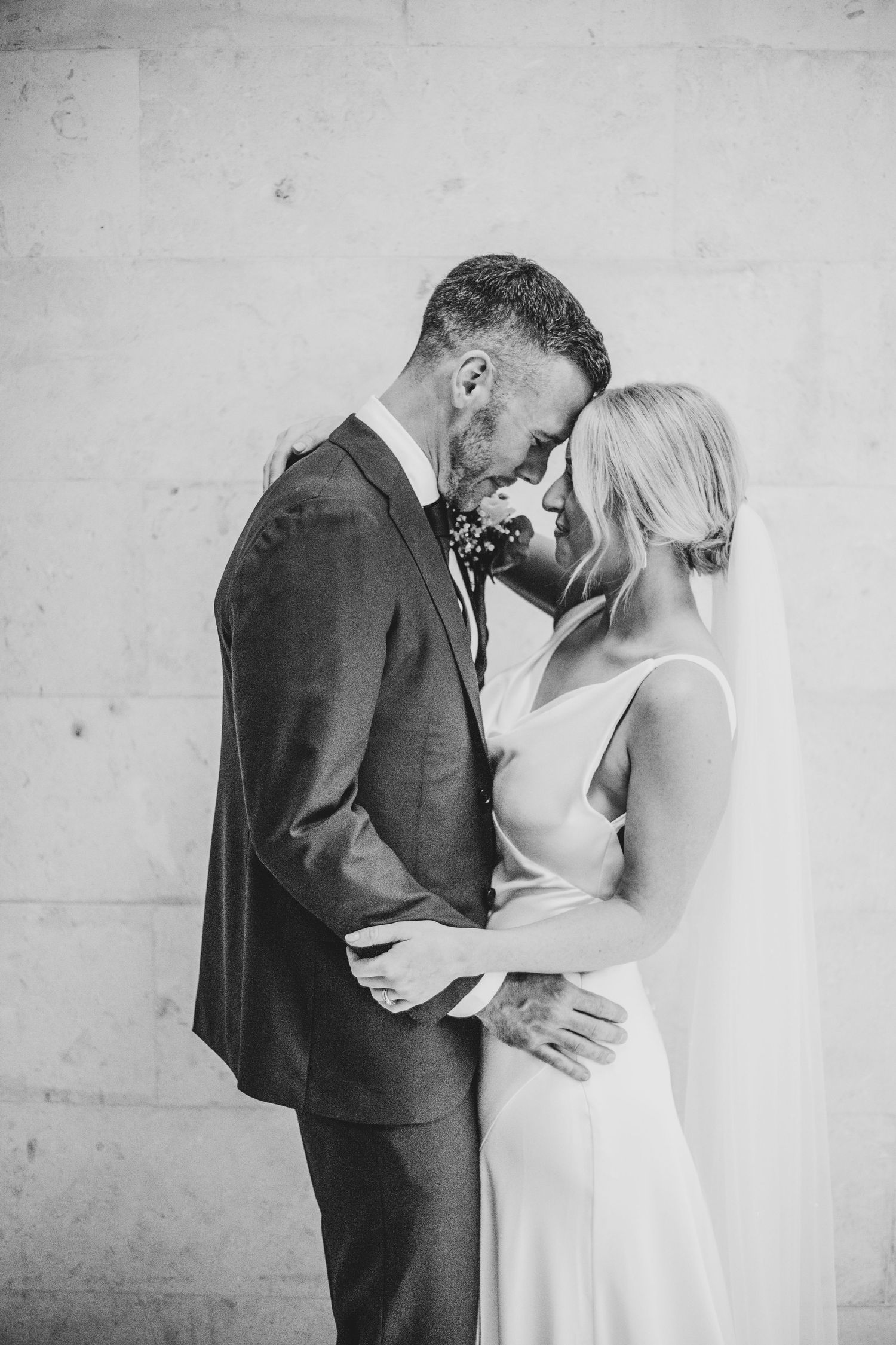 bride and groom embracing in Old Marylebone Town Hall, London by Dominique Lauren photography