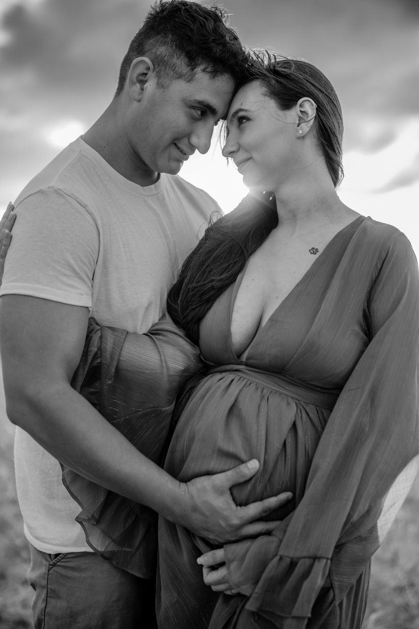 Black and white intimate maternity photos showing tender moments between couple.