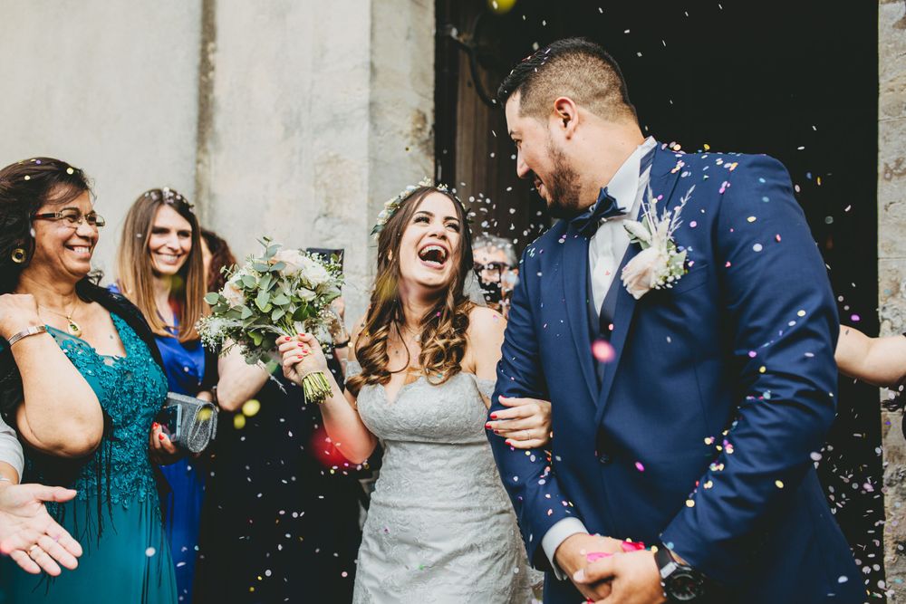 Wedding celebration with confetti being thrown in joyful outdoor celebration.