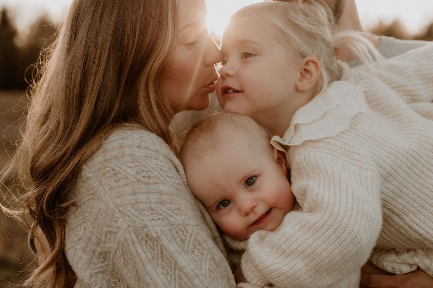 mamma och döttrar kramas i solnedgång med mycket närhet och kärlek