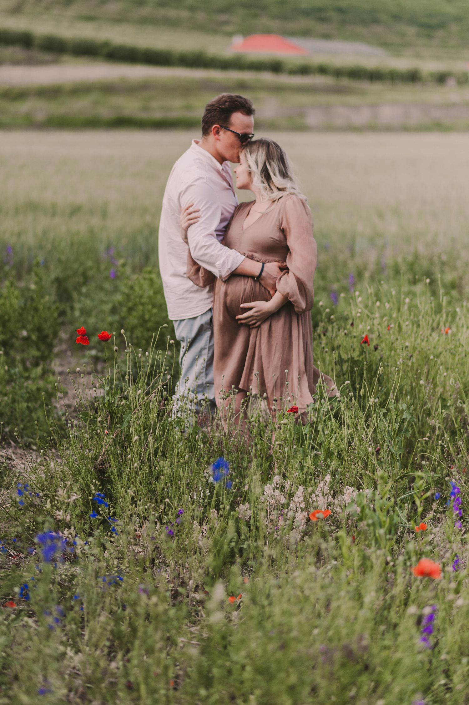 A romantic moment captured in a meadow filled with colorful wildflowers and natural greenery.