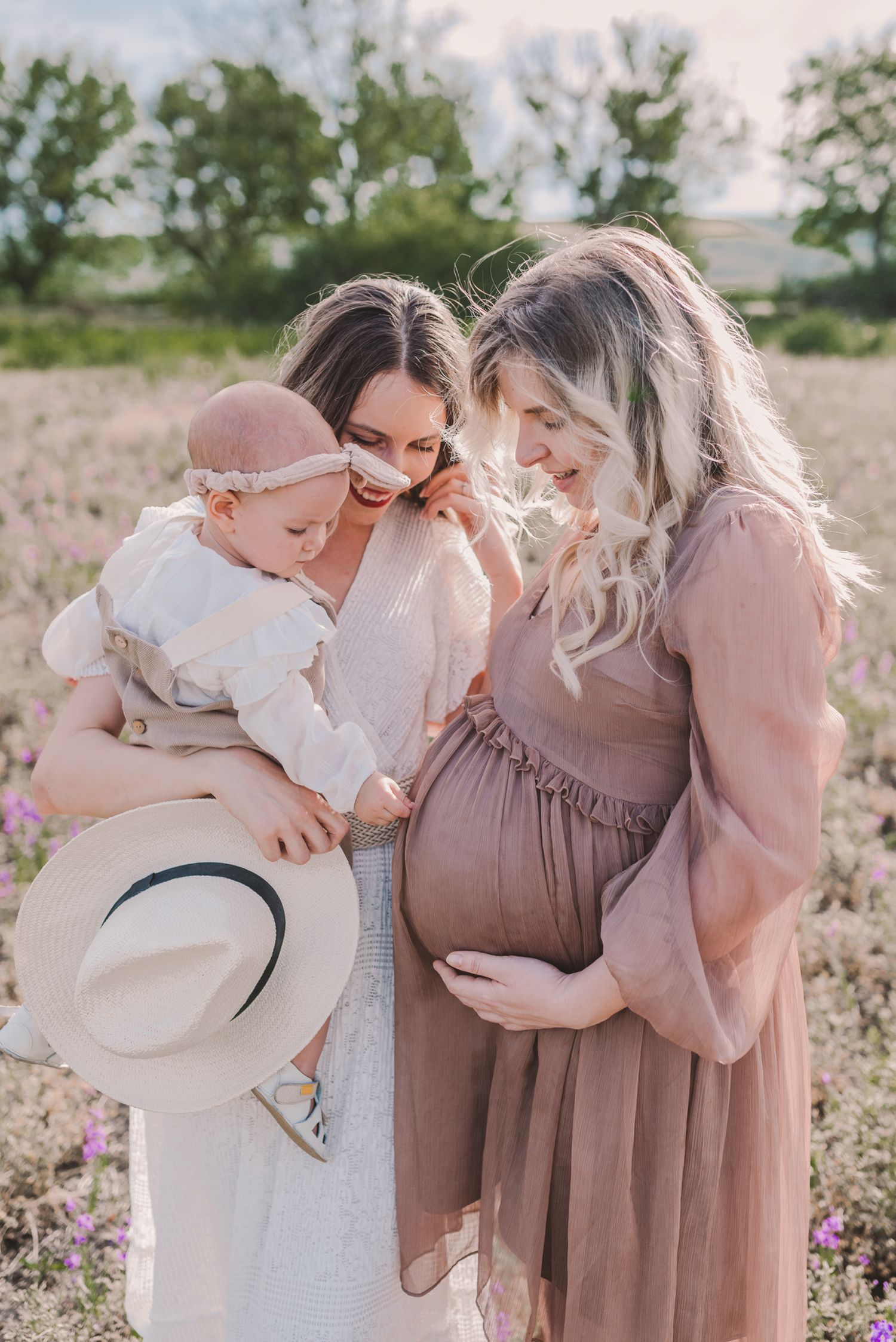 Family members gathering close together in a blooming wildflower field.