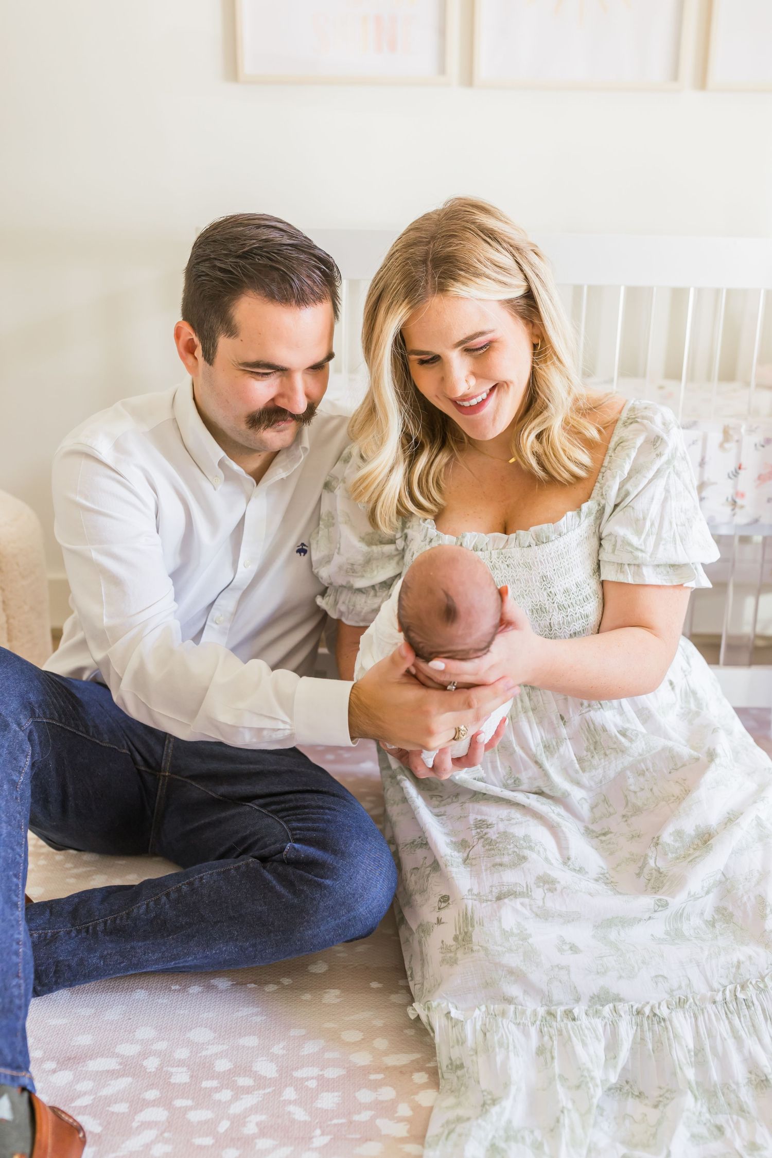 A loving family moment shared on a plush carpet in a serene nursery setting.