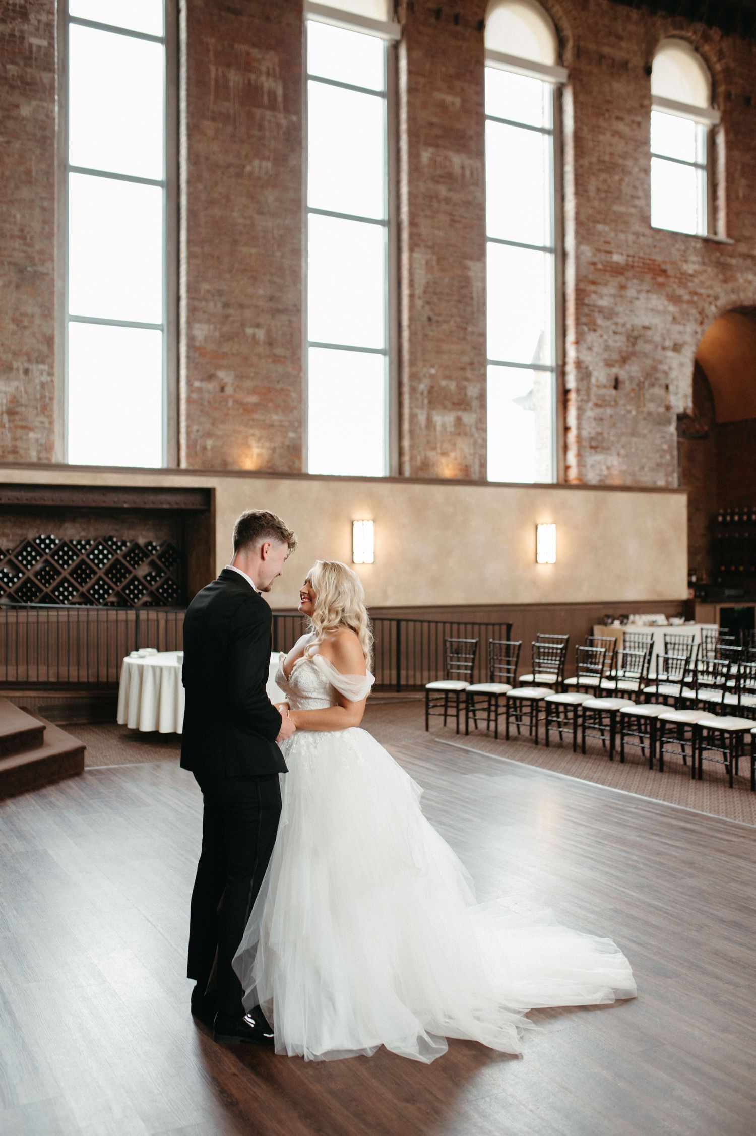 Couple shares intimate moment during first look in historic brick venue.