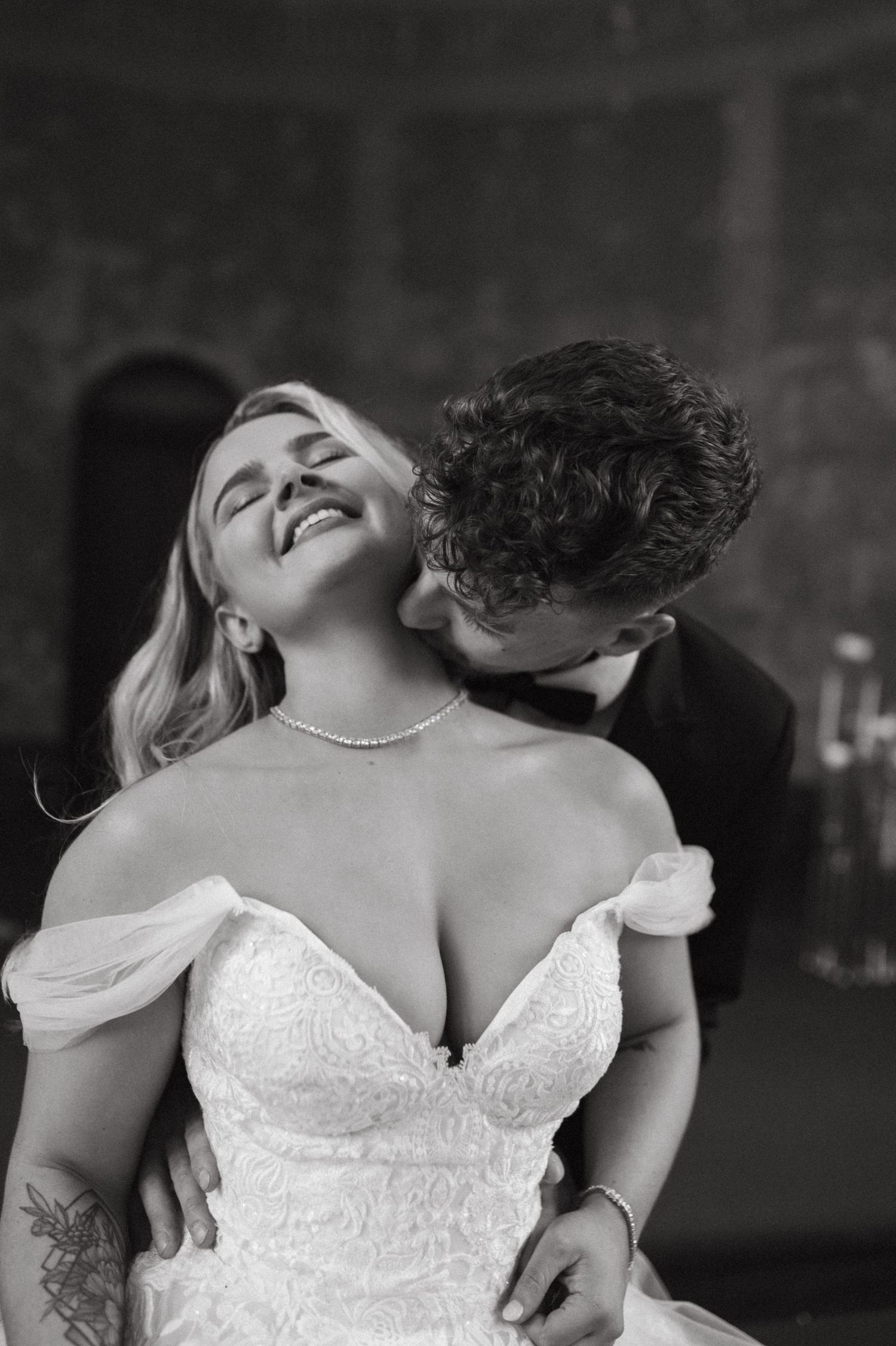 Intimate black and white portrait of a couple sharing a tender moment at their wedding.
