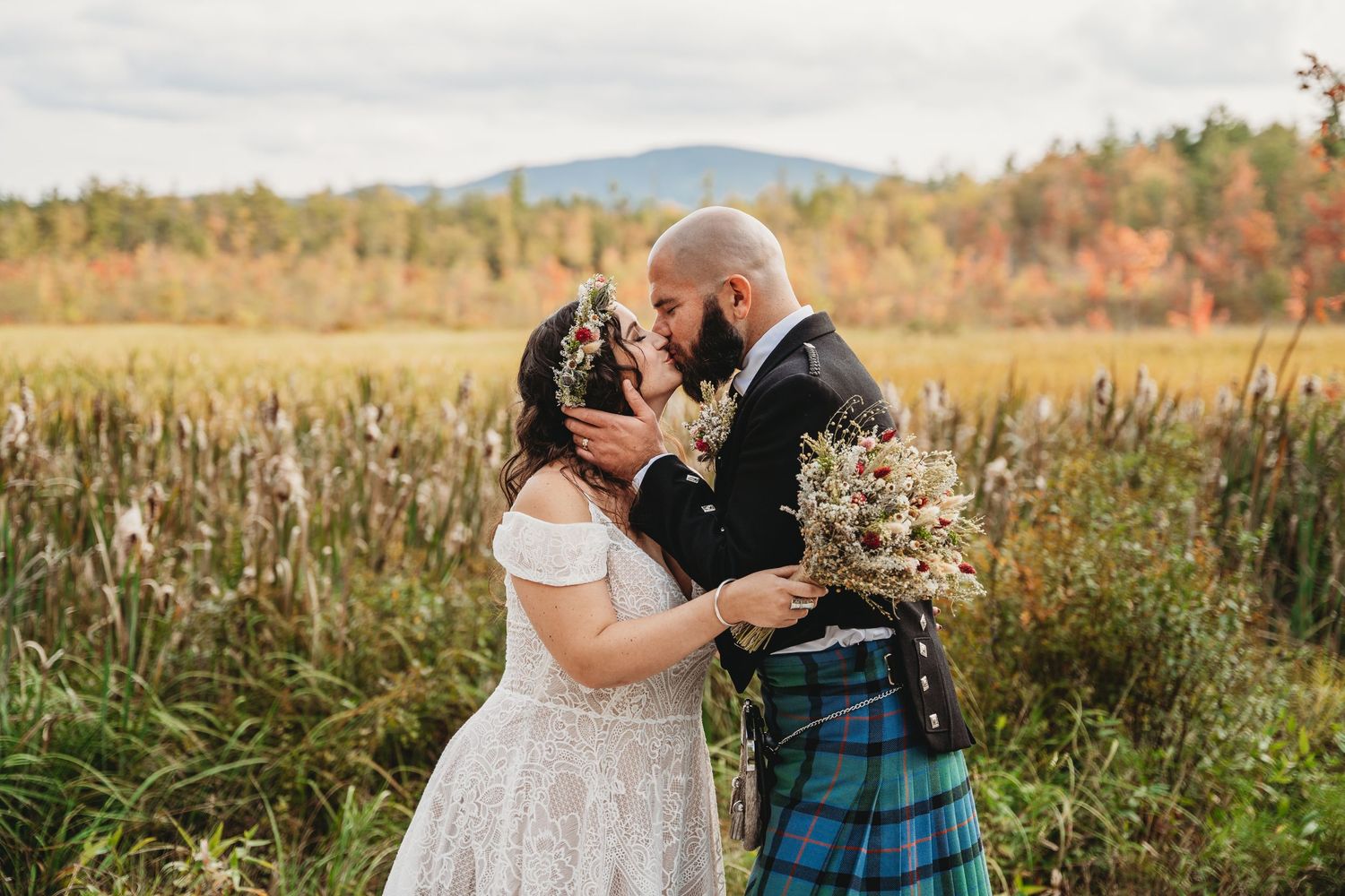 bride and groom sharing a kiss in a golden field in new hampshire