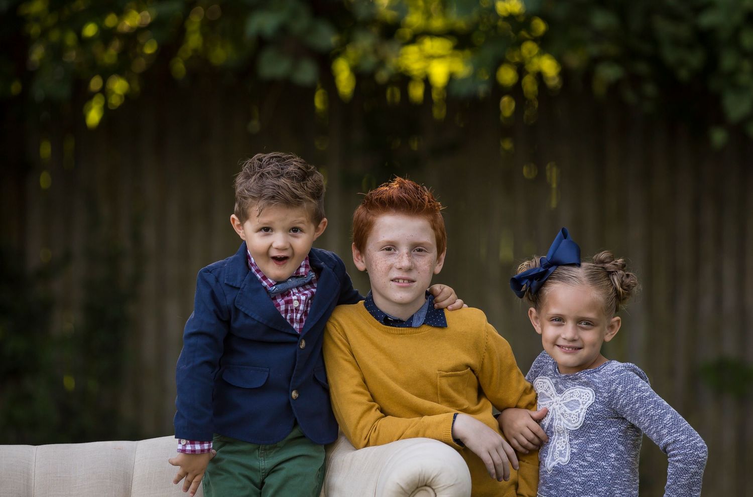Group portrait of children sitting together outdoors at sunset.