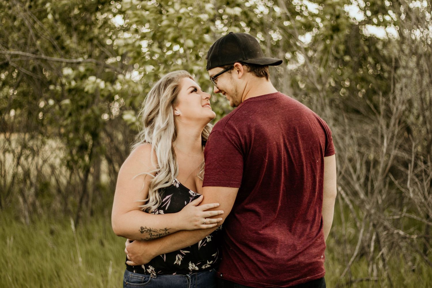 Couple looking at each other in the Saskatchewan forest during an Adventure engagement session