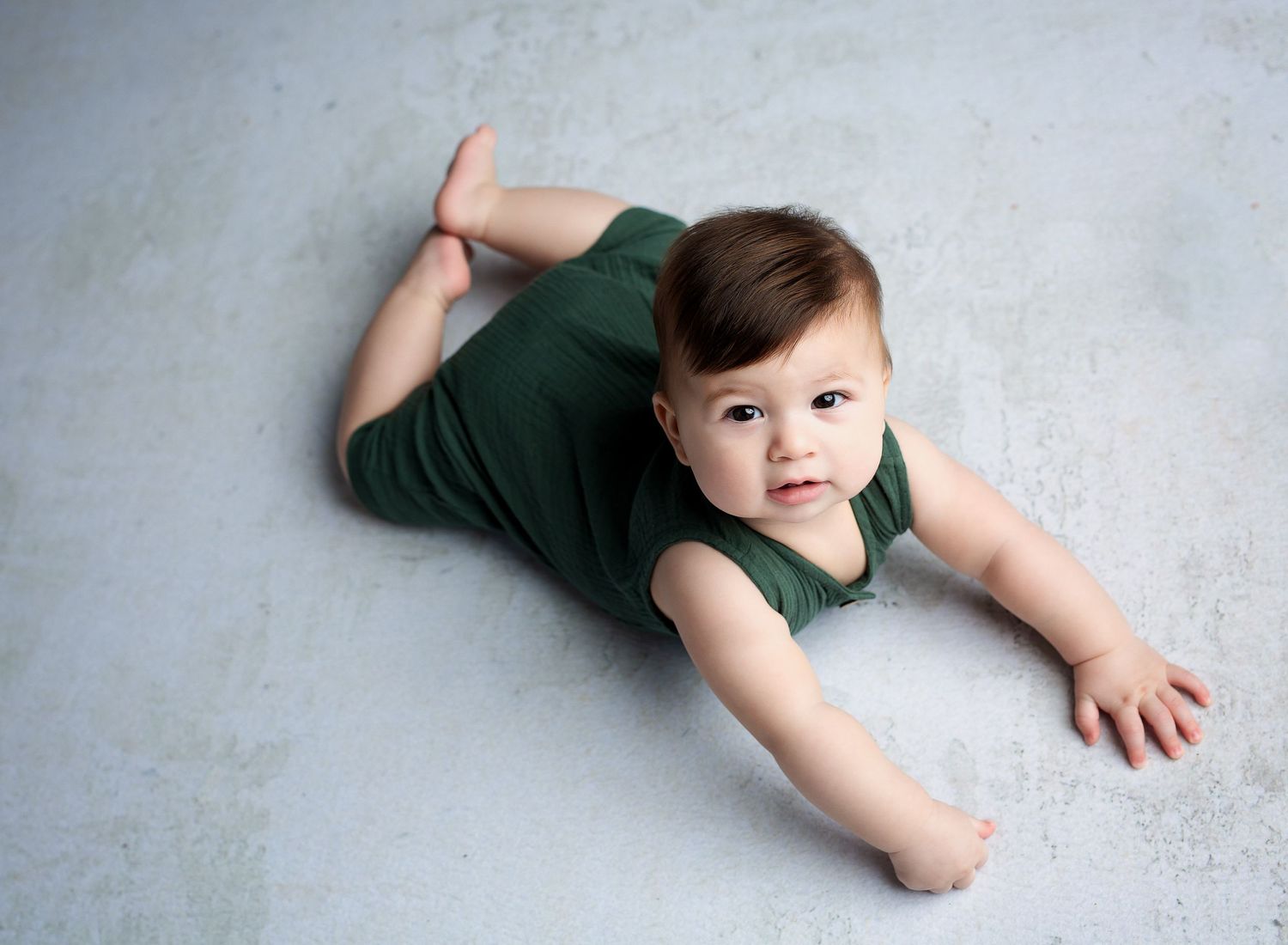 Austin Baby Photographer photographing baby milestone sessions six month baby boy in green romper on tummy
