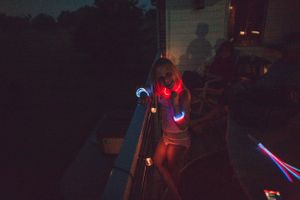 Silhouette of a performer with glowing lights in a dark nighttime setting.
