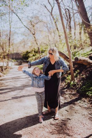 Series of playful yoga poses performed outdoors on a wooded path in spring.