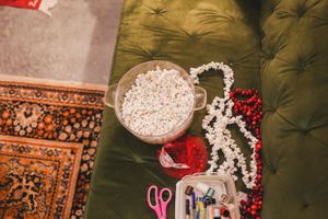 Crafting supplies and decorative items arranged on a green velvet couch.
