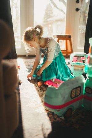 A person in a turquoise dress twirls and spins in a sunlit room creating a flowing motion effect.