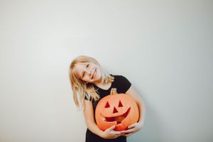 A series of poses with a carved orange pumpkin against a white background.