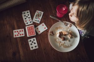 Playing cards laid out on a wooden table with star-shaped cookies on a plate.