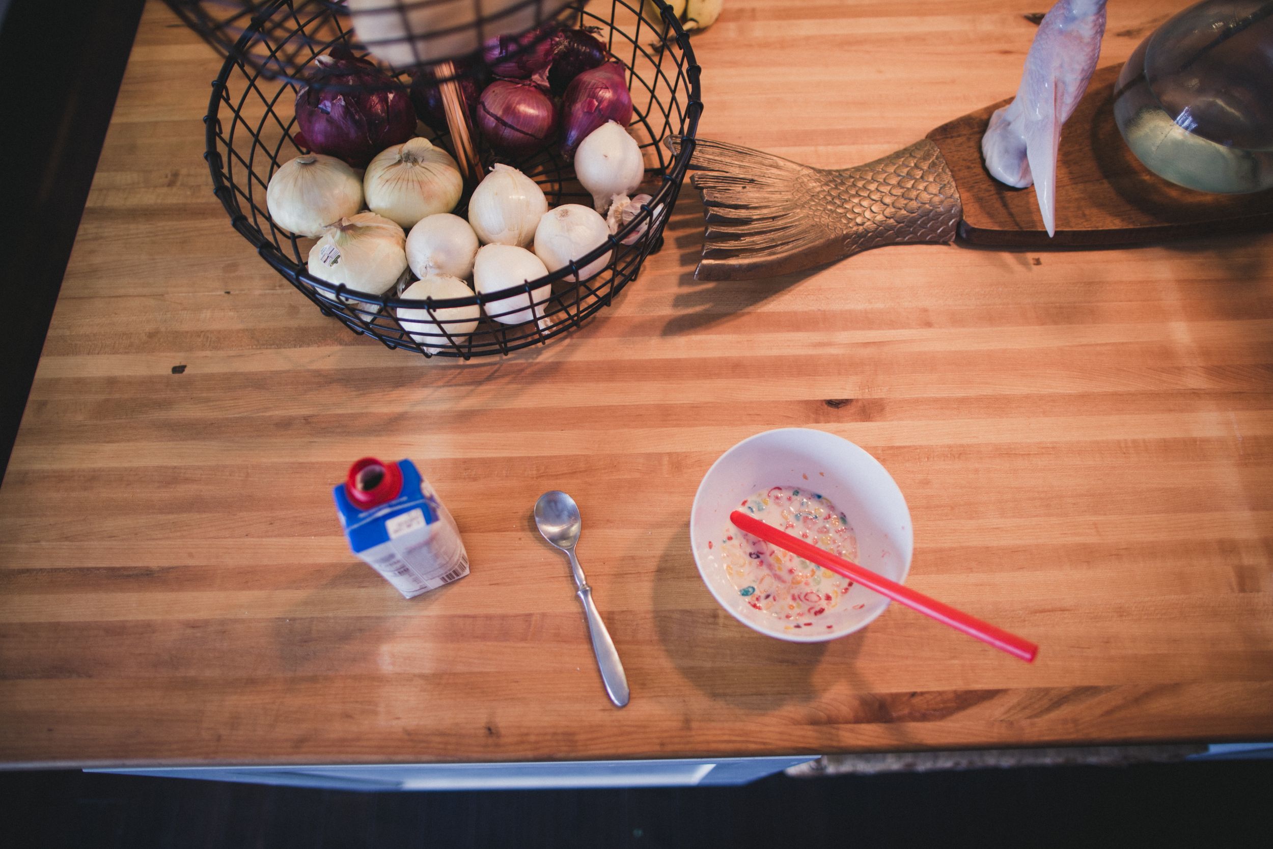 White eggs displayed in a wire basket on a wooden table surface.
