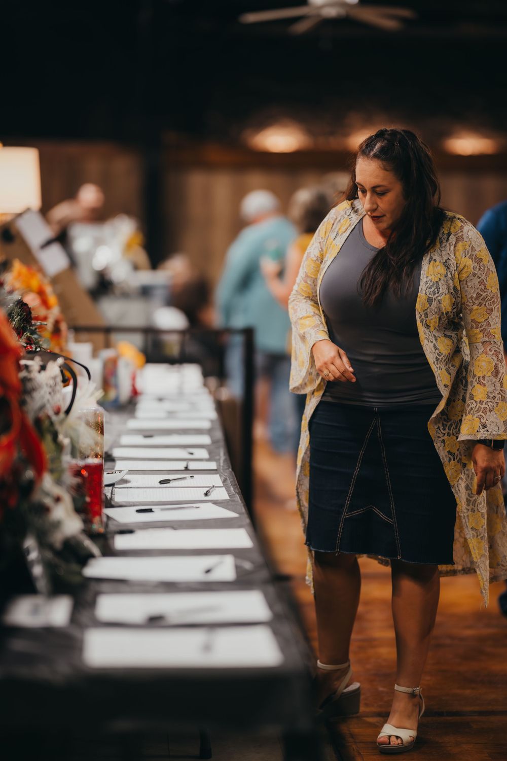 People browsing display tables at an indoor event.