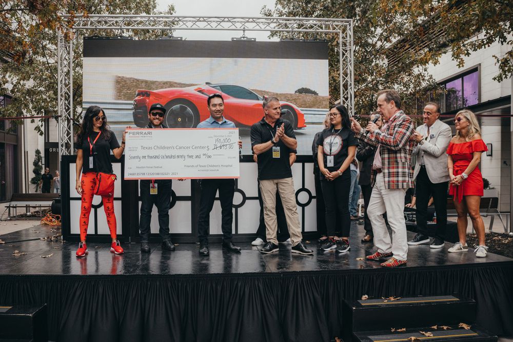 People gathered in front of a large display screen at an event.
