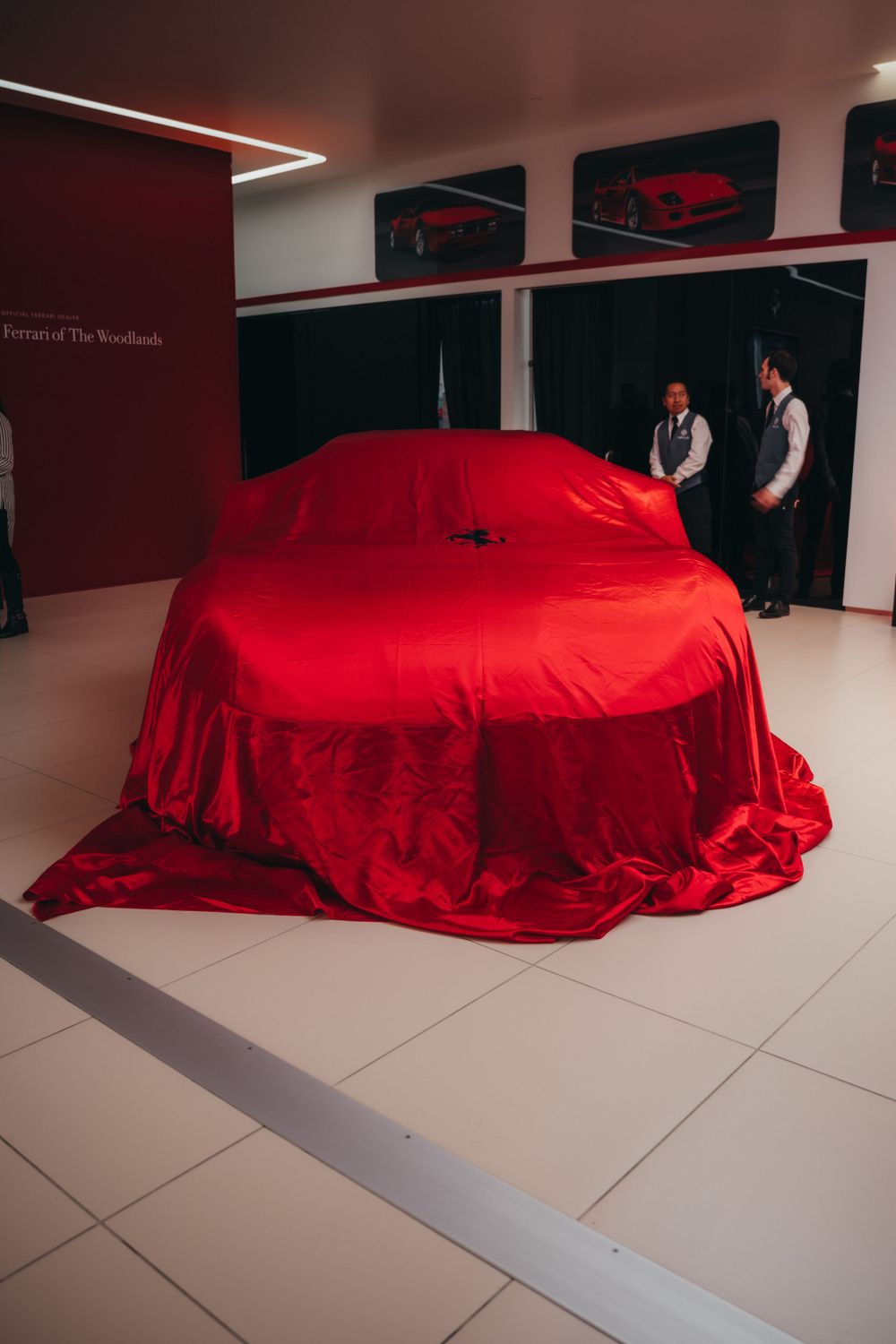 Large vehicle covered with red fabric for dramatic reveal presentation.