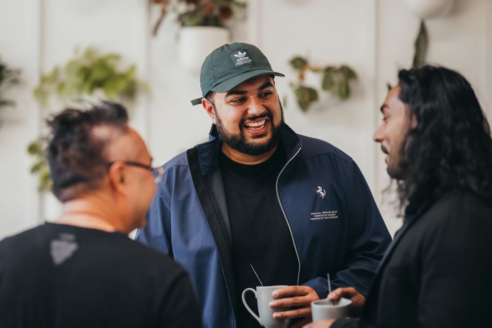 People mingling at a social gathering with drinks in hand.