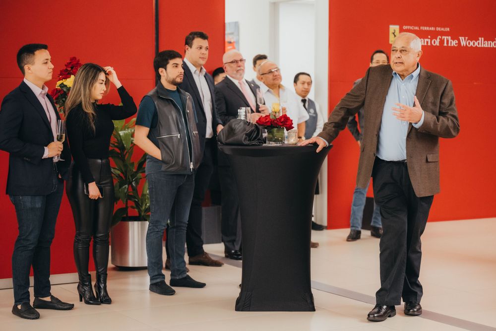 Crowd gathered in modern space with bright red walls for special event.
