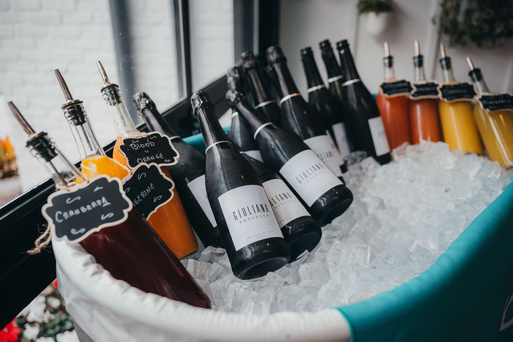 Bottles of wine and champagne chilling in ice buckets at an upscale event.