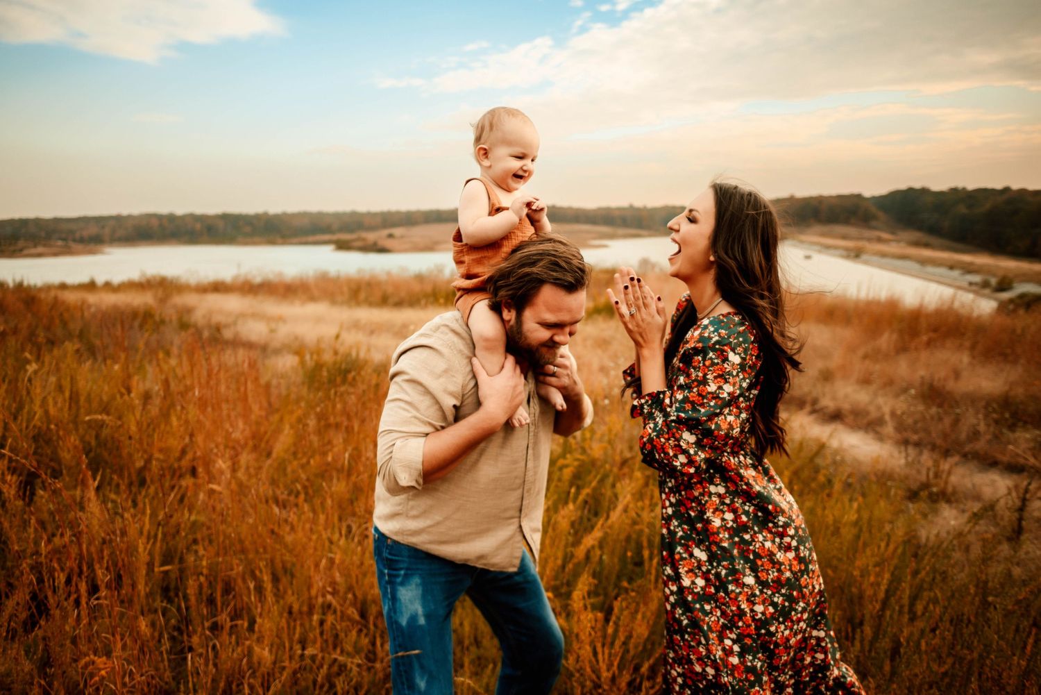 Romantic couple embraces in golden field during sunset photoshoot.