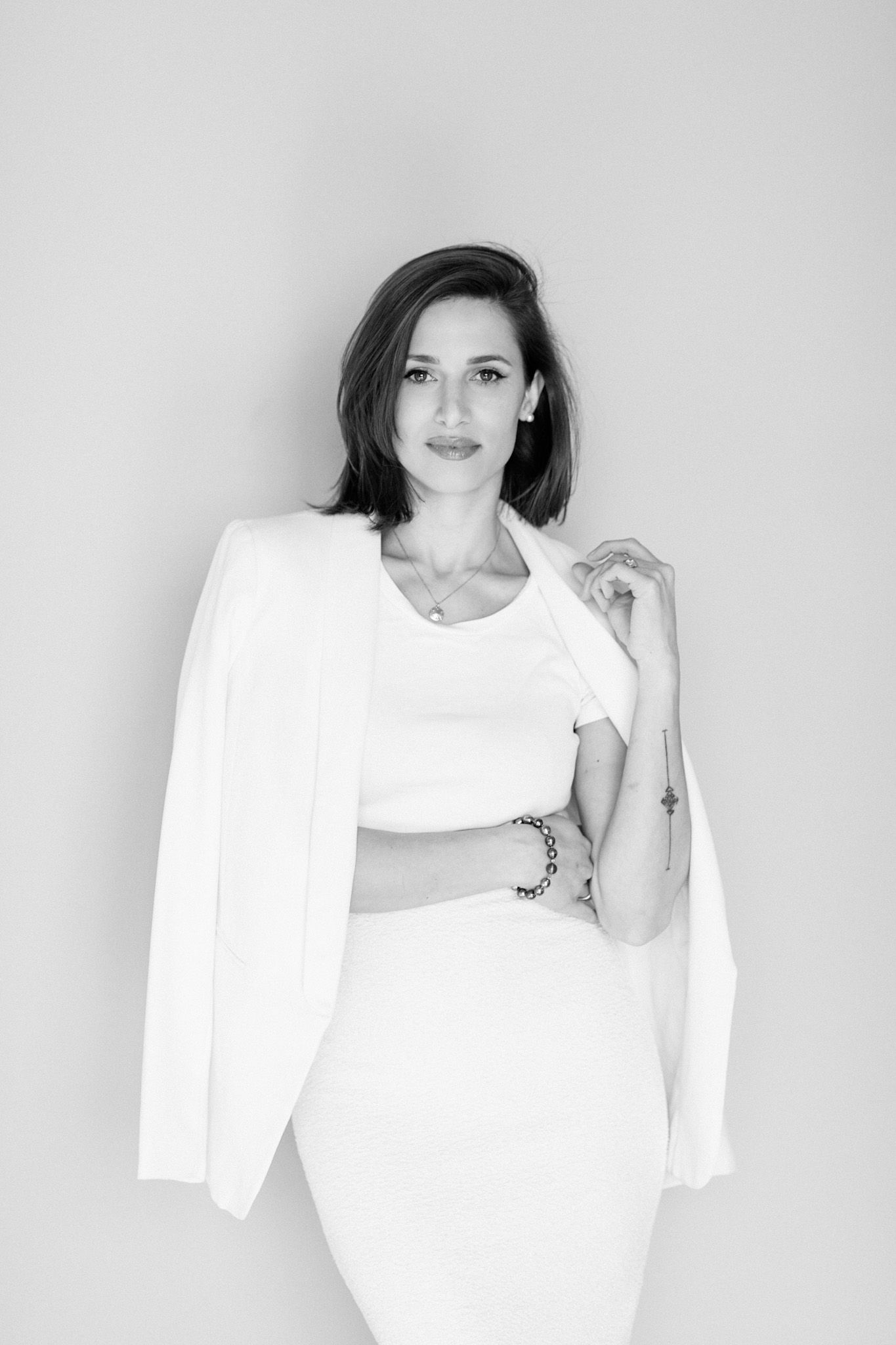 Minimalist black and white portrait showing white blazer and dress outfit.