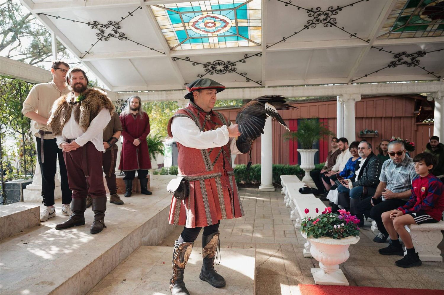 Costumed performer entertains guests during medieval-themed wedding ceremony.