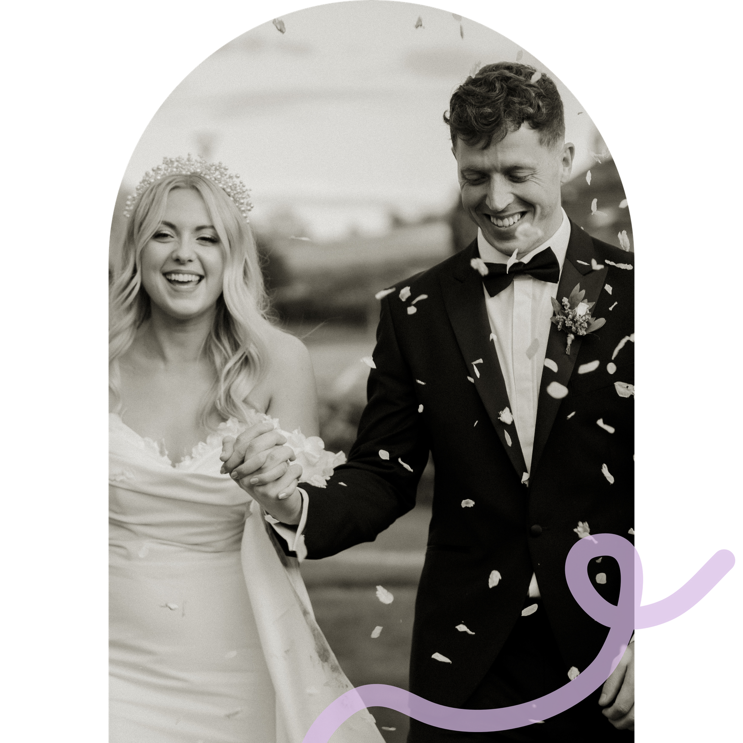 A black and white wedding photo with confetti falling during a celebratory moment.