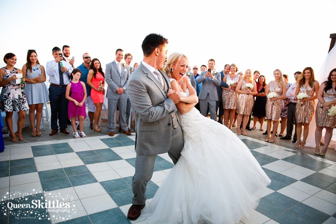 Wedding party dances and celebrates on a checkered dance floor.