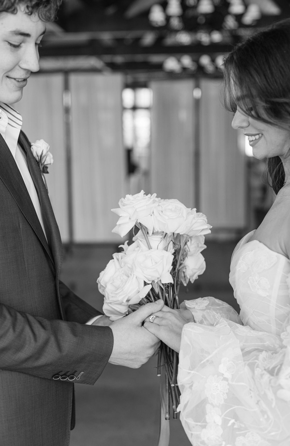 Wedding couple shares intimate moment while exchanging flowers in elegant venue.