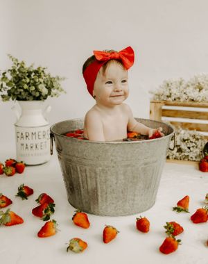 Sweet strawberry themed photoshoot with galvanized tub and rustic farmhouse decor.
