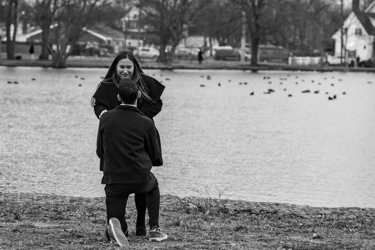 Black and white photograph of proposal moment on winter landscape.