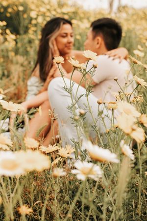A dreamy couple's portrait through delicate yellow flowers in warm golden light.