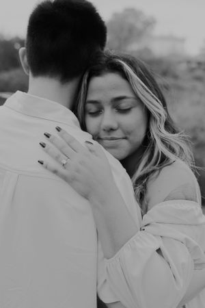 A tender black and white embrace shows a couple sharing an emotional moment.
