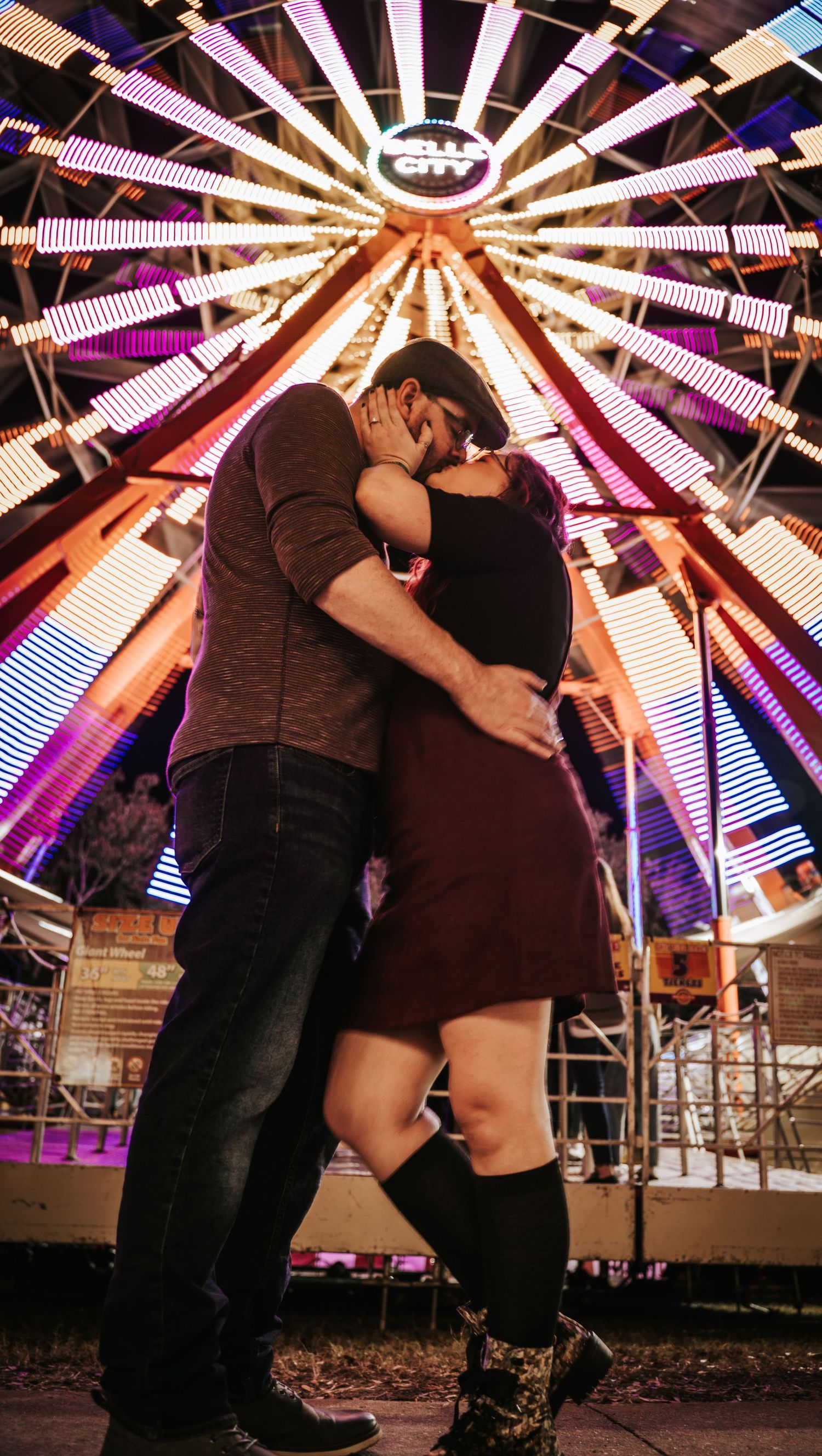 Engaged Couple kissing under ferris wheel at Jacksonville Fair