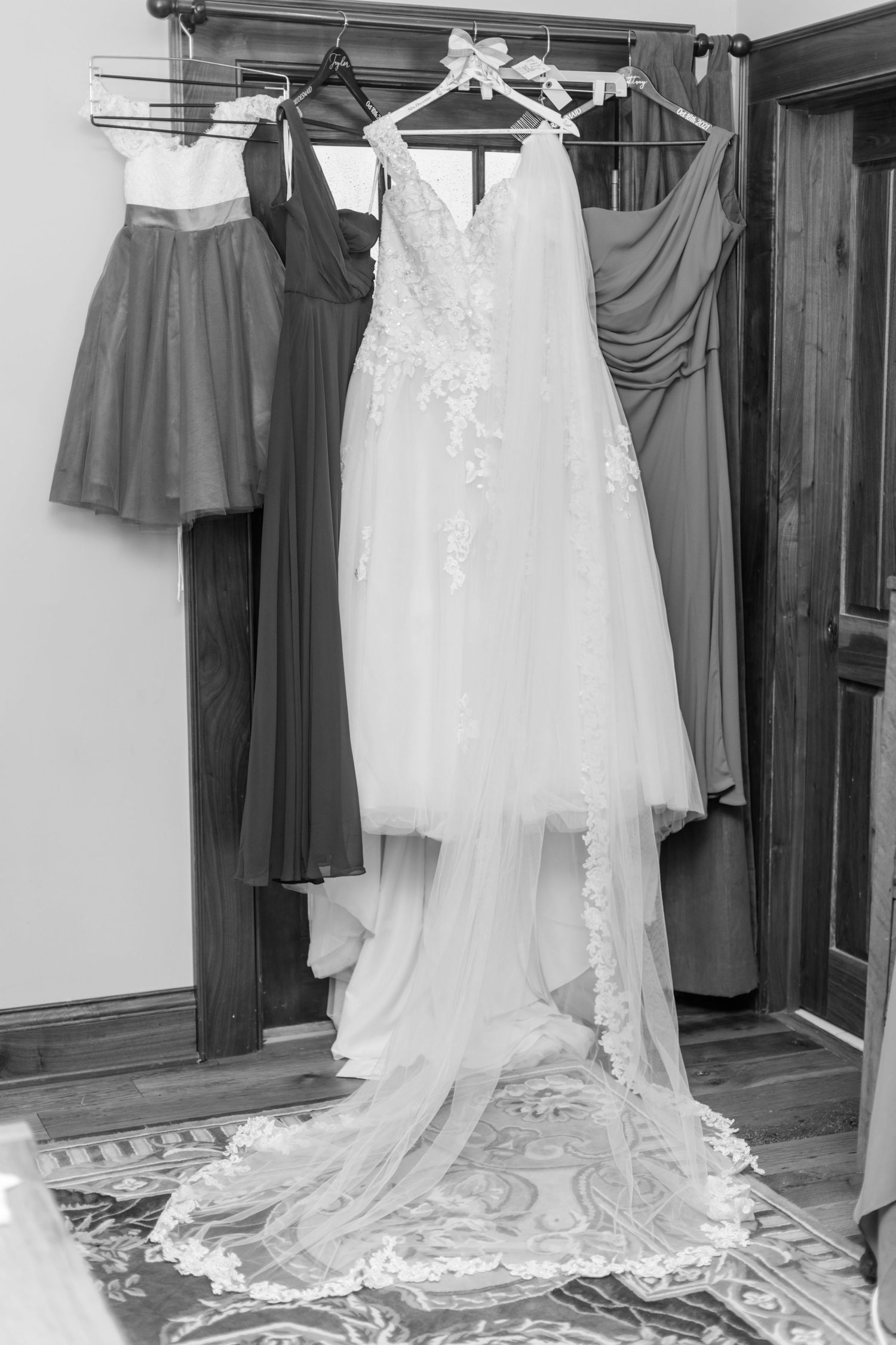 Wedding dresses and bridesmaid gowns hanging on display in a dressing room.