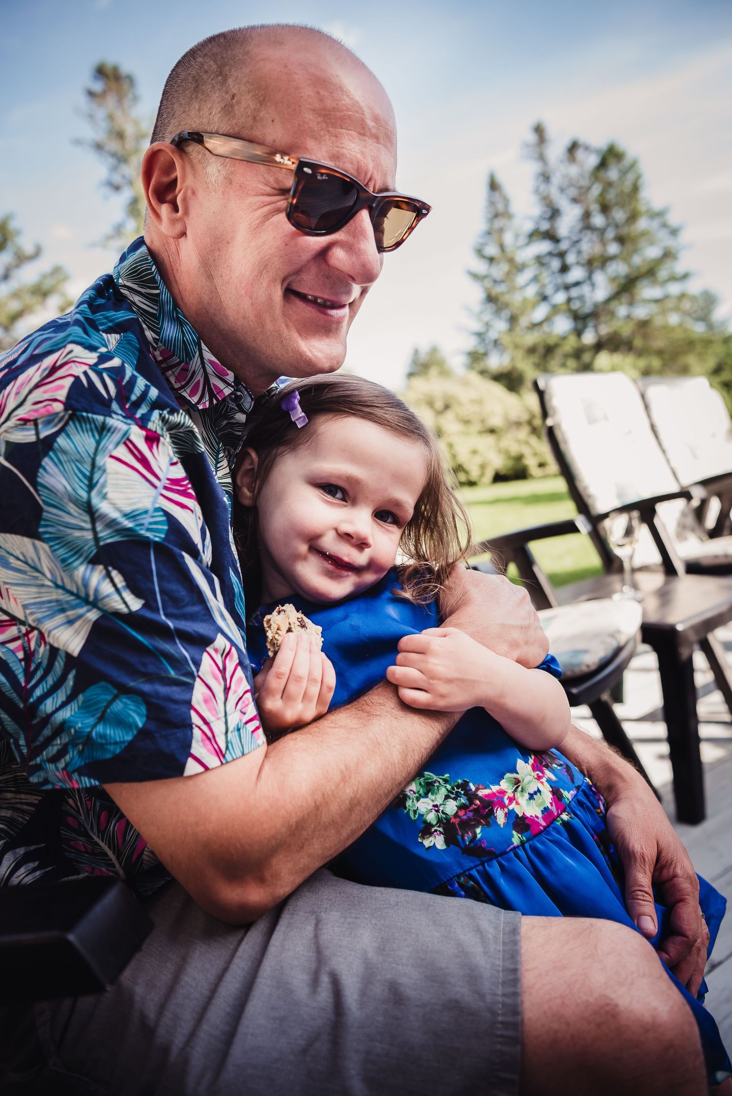 Colour image of a caucasian man holding his young daughter in his arms.