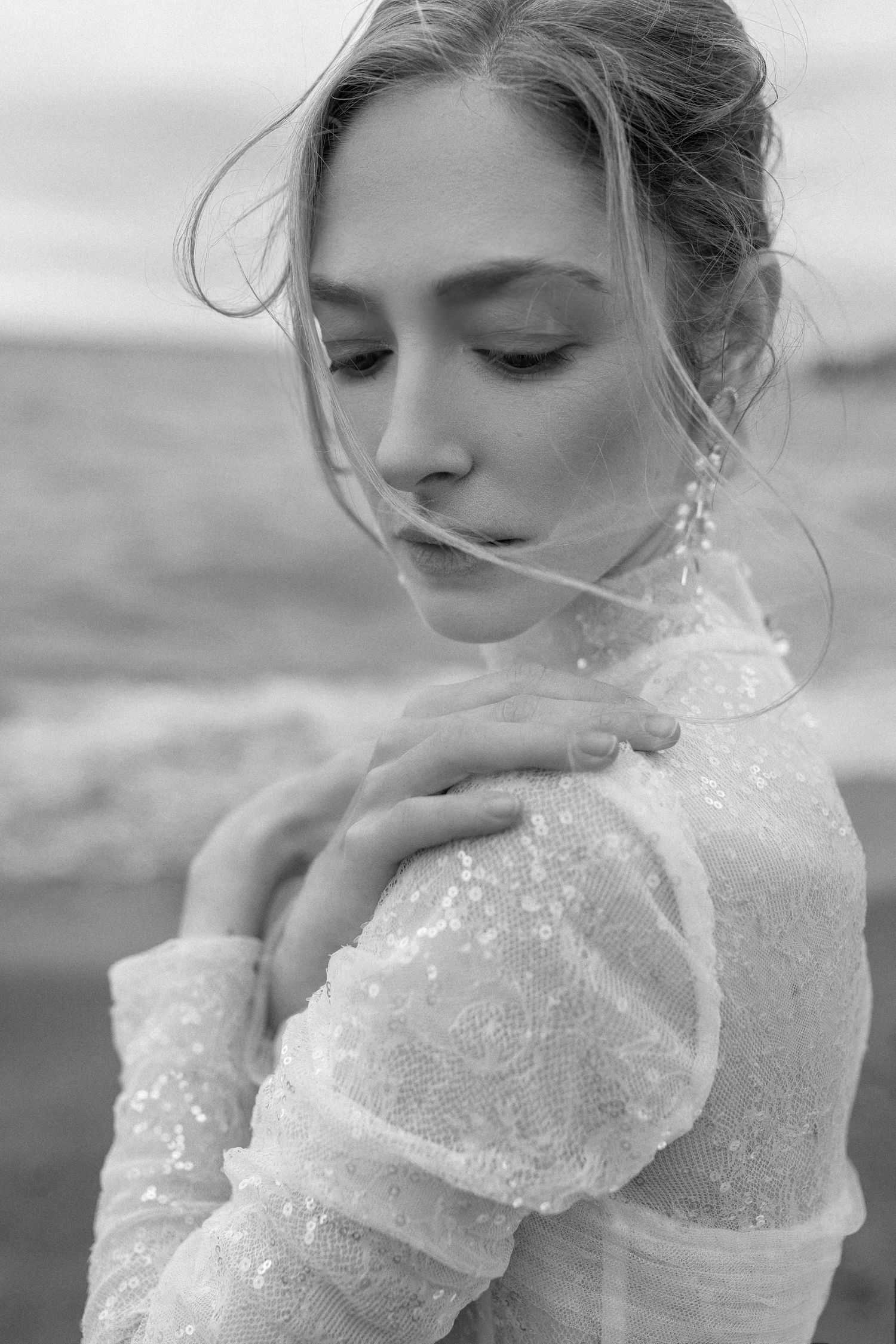 Intimate black and white bridal portrait showing delicate lace details and statement earrings.