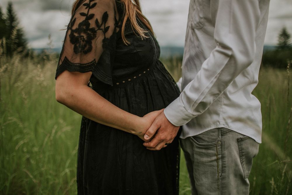 partner holds pregnant belly portland oregon outdoor maternity session