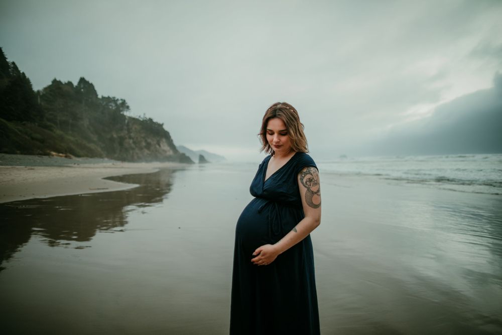 pregnant person holds twin belly on oregon coast maternity photographer portland oregon