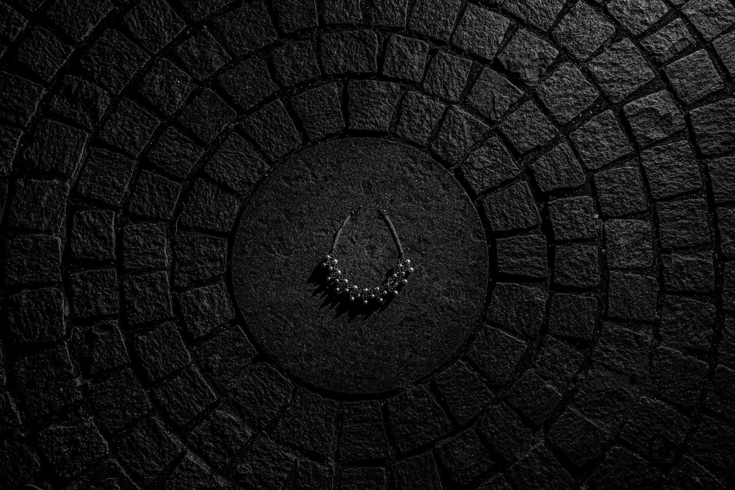 black and white photo of wedding jewellery placed on floor