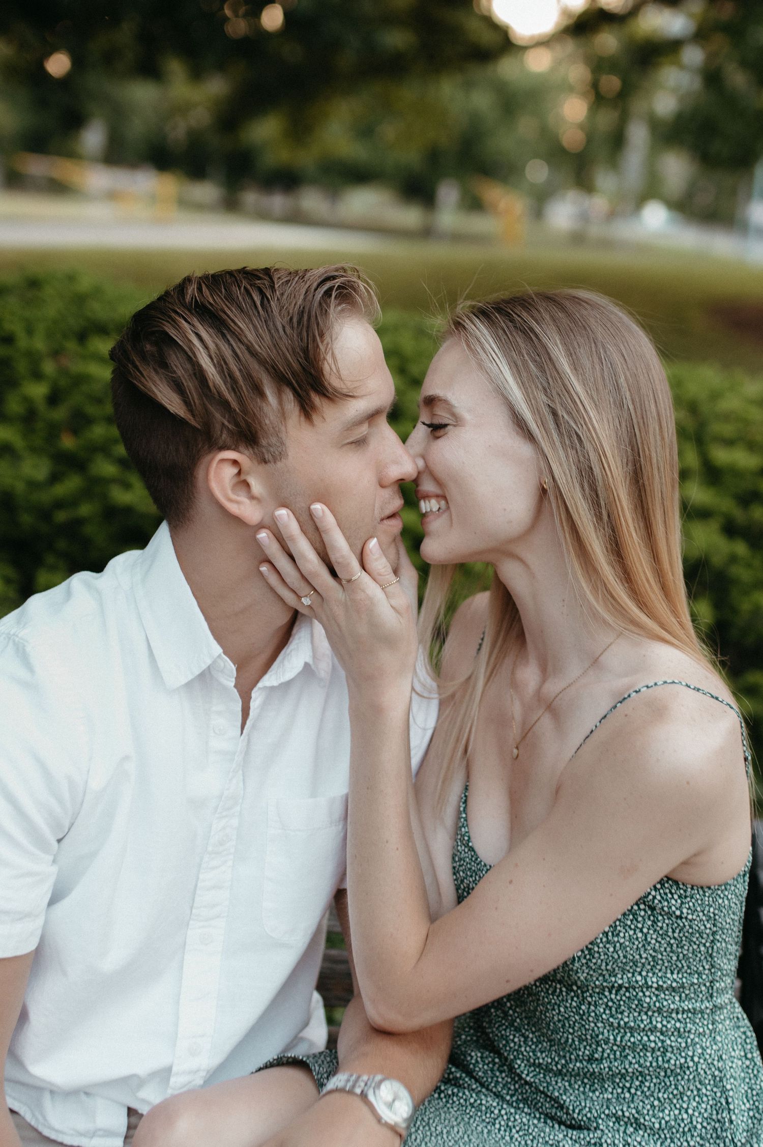 Intimate outdoor portrait of couple sharing a tender moment in a garden setting.