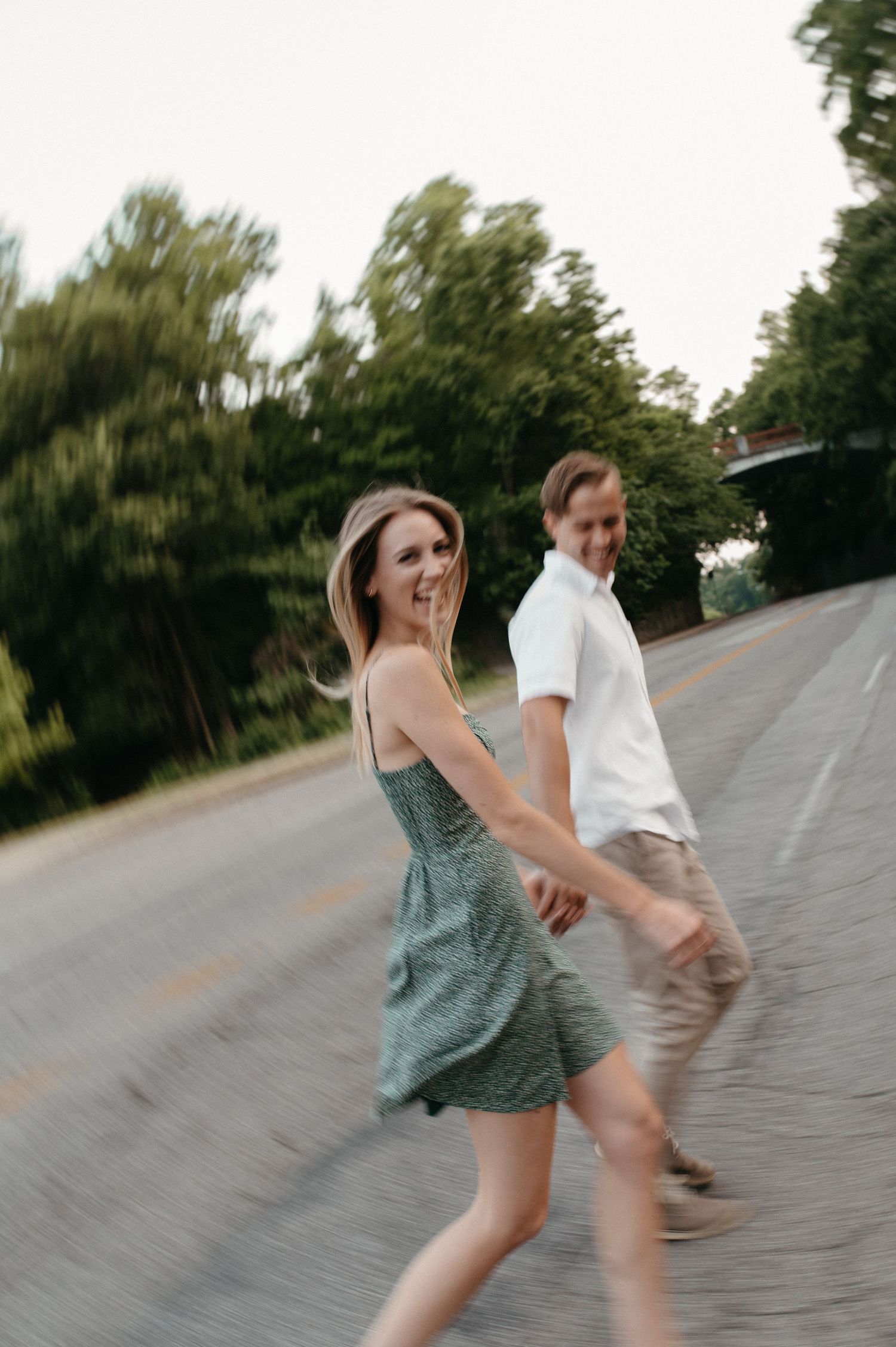 Playful couple walking together on a road with motion blur effect.