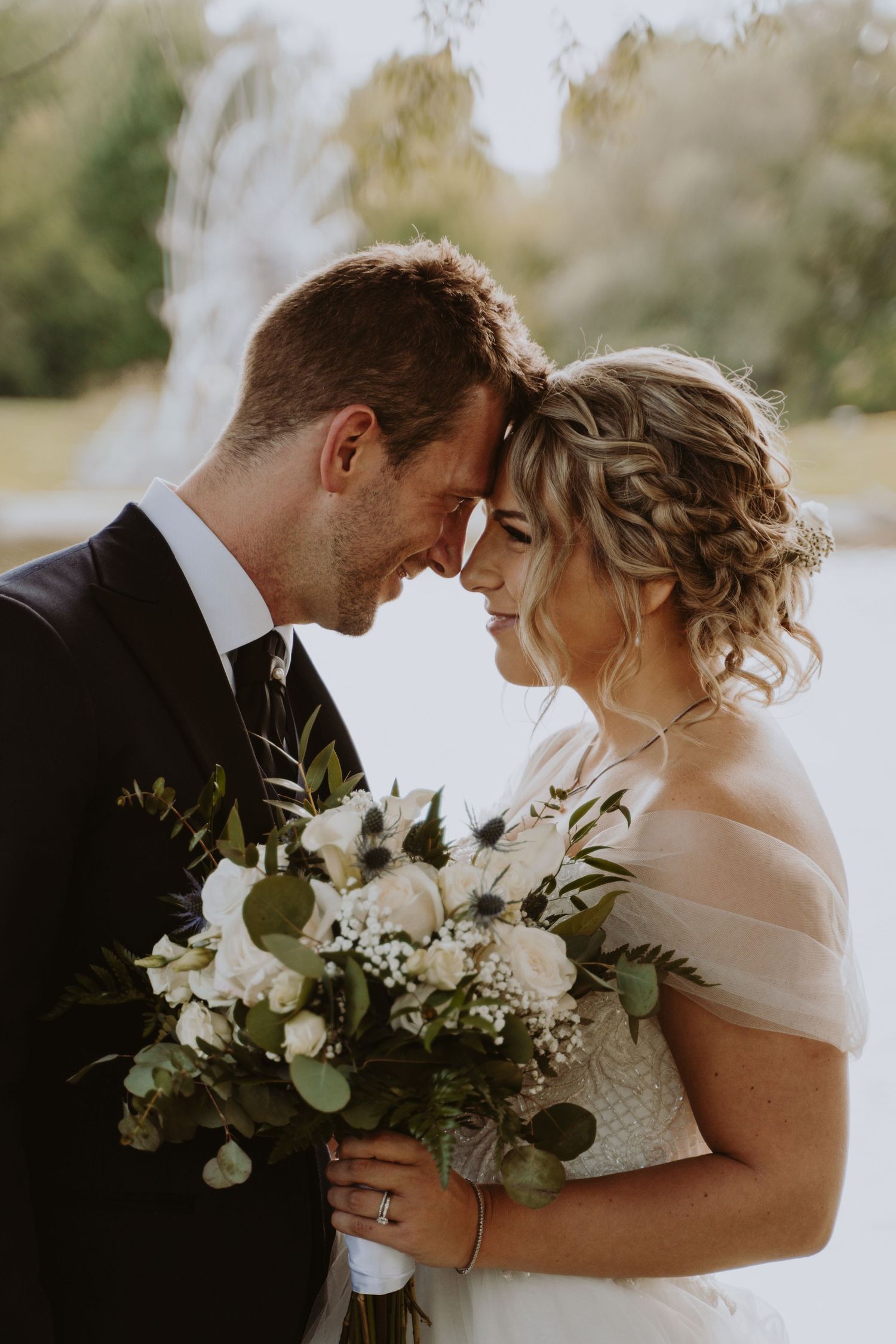 Image of bride and groom touching foreheads.