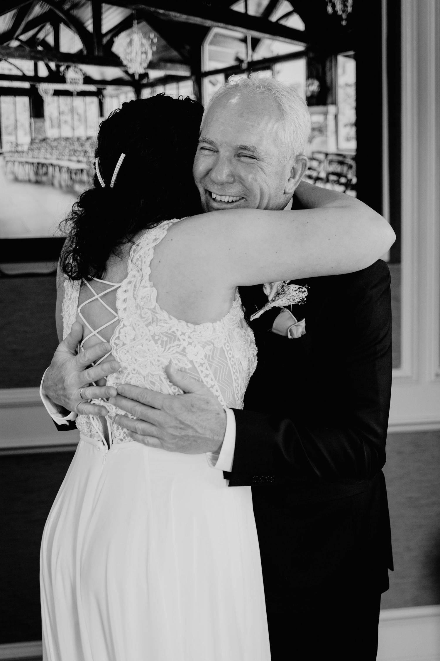 Image of bride and father of bride hugging.