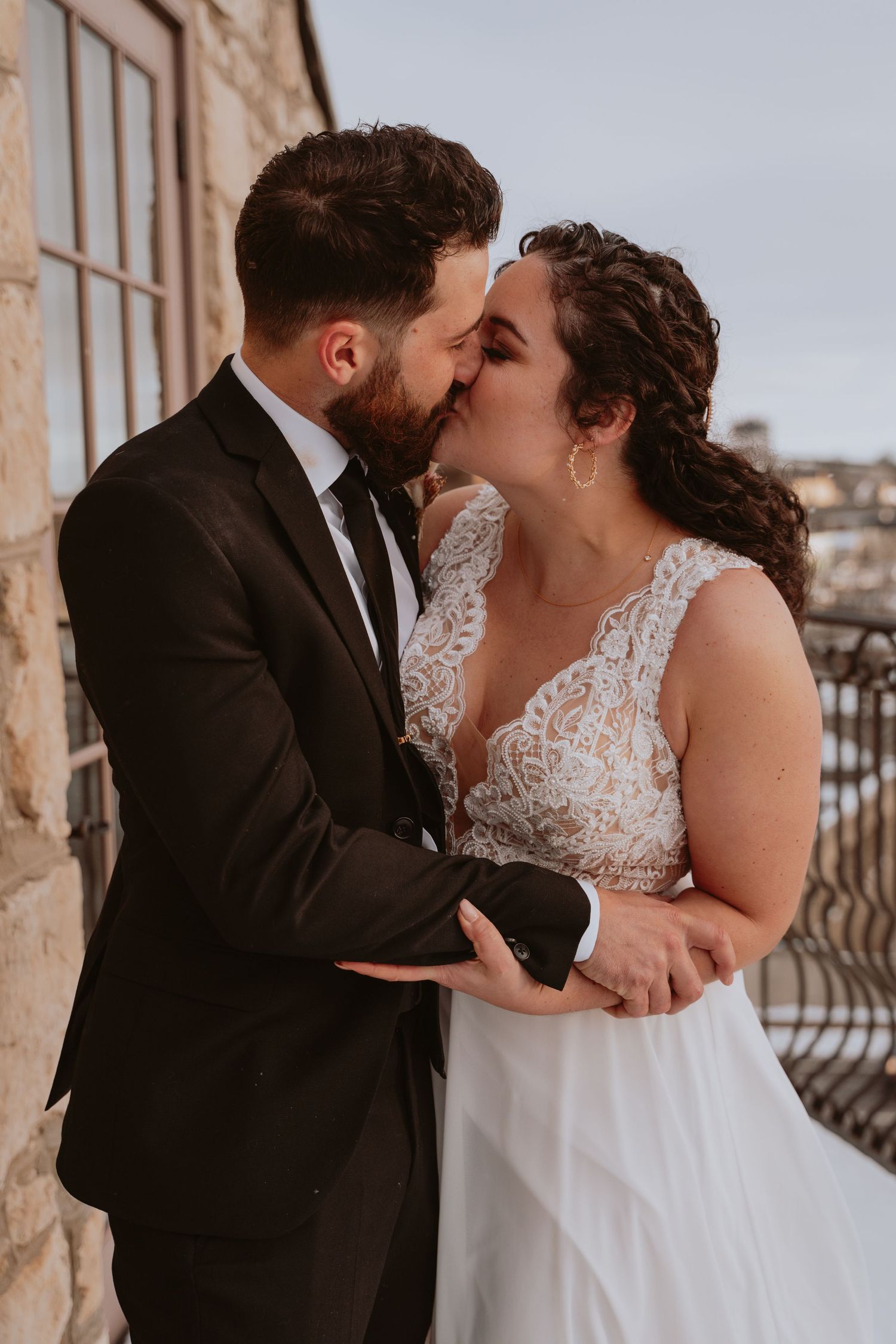 Image of bride and groom kissing on balcony.