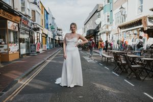a model walking down the lanes wearing a white wedding dress in silk in Brighton