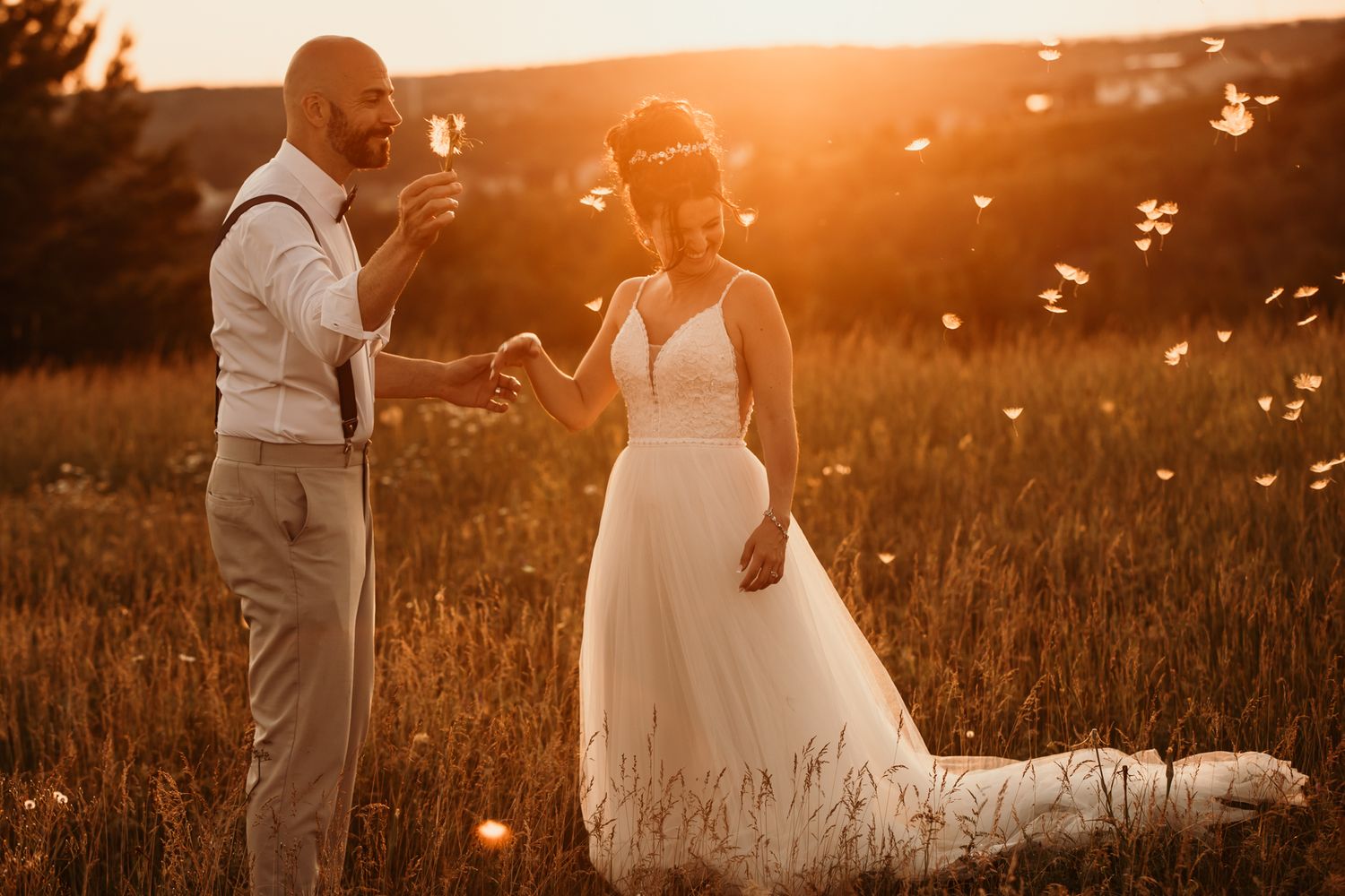 Romantic sunset wedding photos in a golden field with flowing white dress and warm lighting.